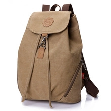 45-degree angle view of khaki canvas backpack featuring drawstring closure and leather logo