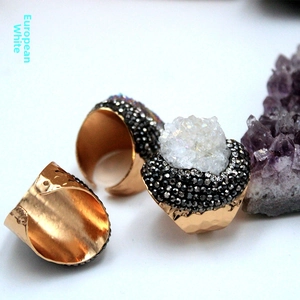 Detail of three adjustable gold druzy rings with white crystal stone and black pave accents