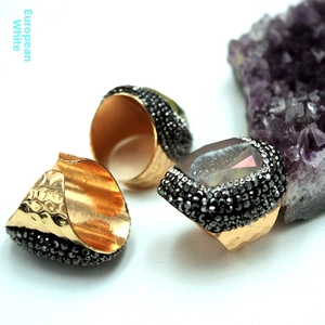 Vista macro del conjunto de anillos martillados en oro con gema rectangular grande y pavé de piedras