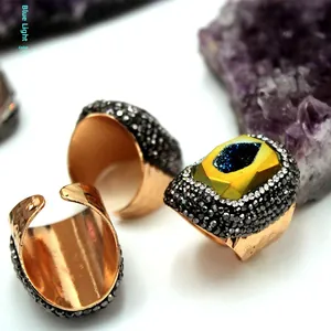 Vista macro del anillo de ágata chapado en oro con textura de cristal azul y piedras brillantes