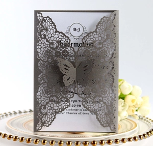 Detailed laser-cut butterfly and lace pattern on a deep navy wedding invitation card