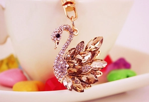 Close-up of golden swan keychain featuring sparkling champagne rhinestones and metal details