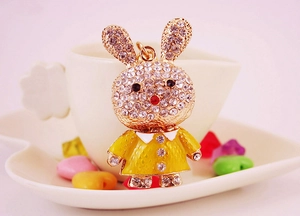 Close-up of golden bunny keychain with yellow outfit and sparkling clear crystal rhinestones