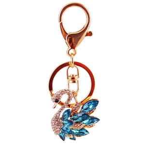Creative crystal swan keychain with blue rhinestones and gold plating on white background