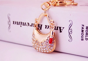 Macro shot of sparkling rhinestone handbag keychain with a mini red lipstick charm