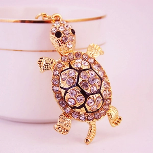 Porte-clés tortue en métal doré orné de strass brillants et de détails en émail noir