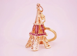Gros plan du porte-clés Tour Eiffel doré avec strass roses et mousqueton en métal chic