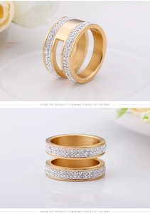 Détail d'une bague double couche dorée avec strass blancs sur une surface miroir chic