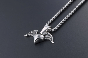 Detailed close-up of a silver heart wing pendant with a sturdy box chain necklace