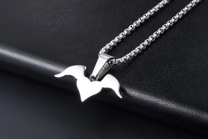 Detailed view of silver heart pendant with wings on a steel box chain necklace