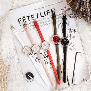 Flat lay of colorful women's leather strap watches with stars on dial over a lifestyle scene