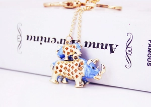 Close-up of golden metal rhinoceros keychain with blue enamel and crystal details