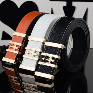 Close-up of leather belts with trident metal buckles in orange, white and black colors
