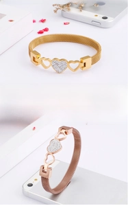 Detail of mesh strap bracelets with zircon heart charms in gold and rose gold