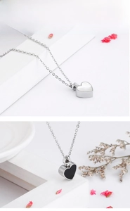 Macro detail of heart-shaped stainless steel cremation urn necklaces in black and white
