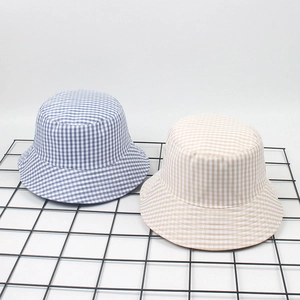 Chic reversible gingham bucket hats in blue and beige checkered patterns for sun protection