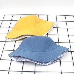 Detail of yellow and blue cotton bucket hats with inner gingham patterns on metal grid