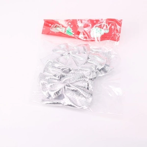 Detail of silver glitter Christmas tree bows in clear packaging with red header card