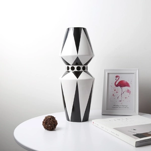 Detail einer modernen geometrischen Keramikvase mit schwarz-weißem Muster auf dem Tisch