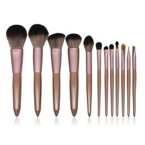 Detail showing twelve professional makeup brushes with rose gold handles and soft bristles