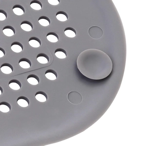 Dettaglio del filtro per lavandino in silicone grigio con fori di scarico e ventosa di fissaggio