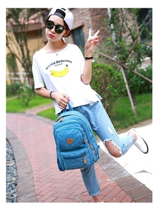 Outdoor shot of a blue canvas backpack featuring multiple pockets and durable straps