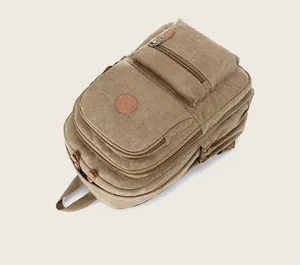 Top view detail of durable khaki canvas backpack showing multiple zippered compartments