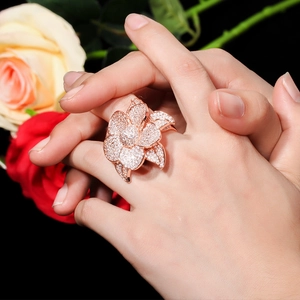 Sparkling AAA zircon flower ring in rose gold finish worn by a model on dark background