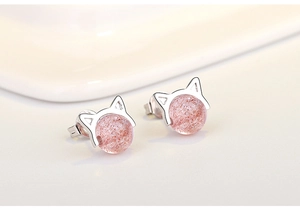 Macro shot of silver cat ear stud earrings featuring pink strawberry crystal beads