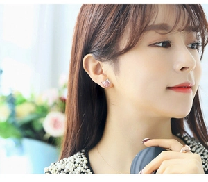 Close-up of cat-shaped silver earrings with pink strawberry quartz on female model