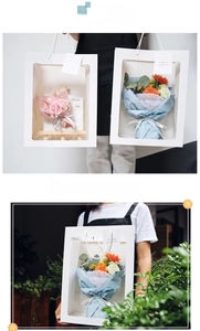 Close-up of white gift bag with transparent window and white handle for flowers