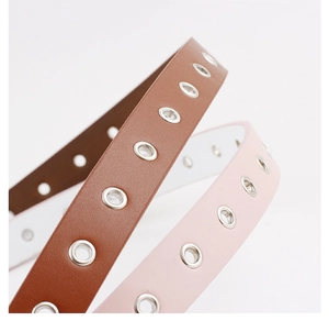 Close-up of brown and pink leather belts featuring heart buckles and metallic eyelets