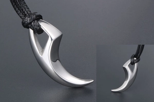 Detail of silver wolf tooth pendant with smooth finish on a black braided cord necklace