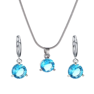 Vue détaillée du collier et des boucles d'oreilles en argent sertis de zircons bleus