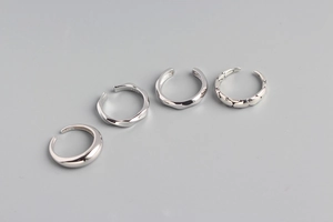 Detailed macro view of four S925 sterling silver minimalist rings with various textures