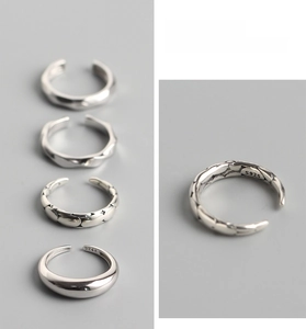 Detailed close-up of S925 sterling silver stamp on minimalist rings in a 4-piece set