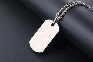 Polished stainless steel rectangular dog tag pendant with a braided chain close-up