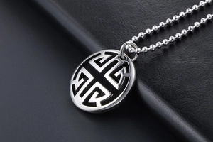 Detailed view of vintage hollow circular silver pendant necklace on a dark leather texture