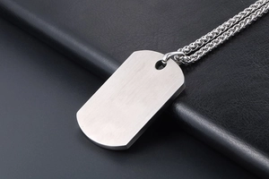Polished silver titanium steel pebble pendant necklace displayed on a black leather background