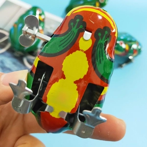 Close-up of vintage metal wind-up frog toy bottom showing the H-01 Made in China mark