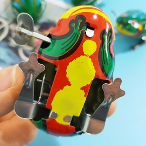 Detail view of the mechanical clockwork base and Made in China print on the tin frog toy