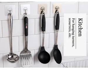 Transparent adhesive wall hooks for kitchen utensils showing heart-shaped design on tiles
