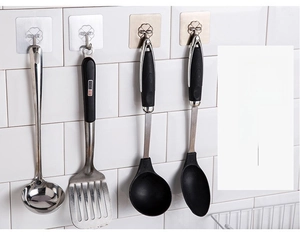 Transparent adhesive wall hooks for kitchen utensils showing heart-shaped design on tiles