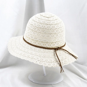 Detail of white lace crochet sun hat with delicate wavy brim and woven cord ribbon