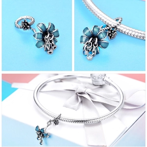 Close-up of blue enamel flower charm with zircon inlays on a silver snake chain bracelet