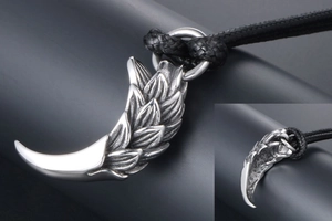 Detail of vintage dragon scale tiger tooth pendant with intricate feather texture
