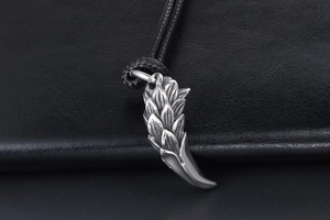 Close-up of retro dragon scale tooth pendant in silver steel with black cord