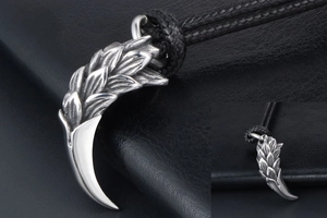 Detailed macro view of vintage dragon scale tiger tooth pendant with black braided rope