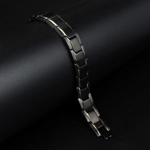 Macro shot of men's titanium steel health bracelet with gold accents on black base