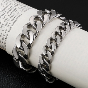 Polished silver Cuban link bracelets in two widths displayed on a cylindrical prop